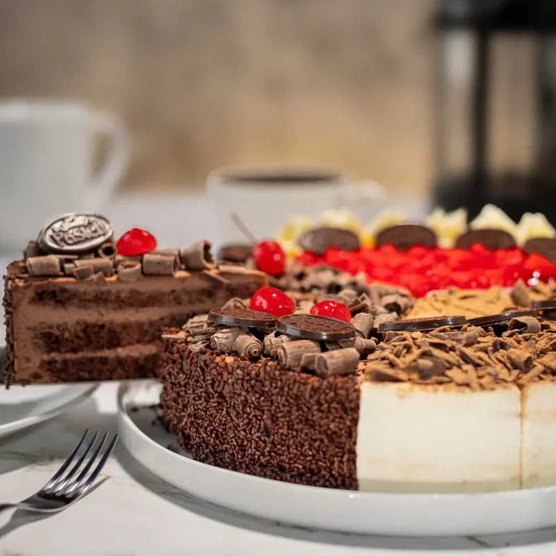Descubre el Pasteli Combinado, ideal para quienes no pueden decidir. Elige 3 sabores de nuestra Línea Gourmet y combínalos. Incluye opciones como Arlequín de Fresa, Selva Negra, Tiramisú y 3 Leches Cremoso. 12 rebanadas de repostería artesanal en Chihuahua, perfecto para probar de todo en tus eventos y regalos a domicilio.