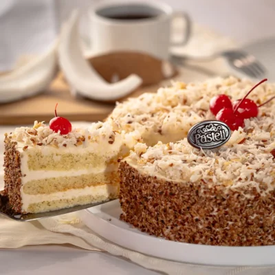 Un esponjoso Pan Genoise humedecido en jarabe de vainilla, cubierto con deliciosa lluvia de nuez y una suave capa de Coco Ángel. Una delicia celestial en cada bocado. Sorprende a tus invitados con repostería fina, servicio a domicilio disponible en Chihuahua.