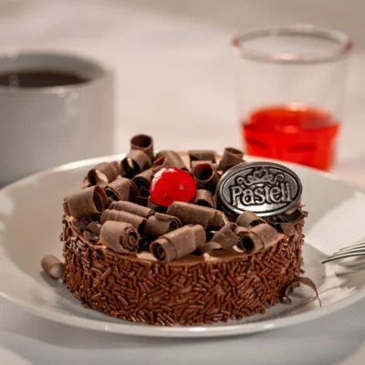 Pan Genoise de chocolate esponjoso, bañado en jarabe con licor de cerezas, cubierto con remolinos de chocolate semiamargo y granillo Turín. Un fascinante juego de texturas y sabores. Nuestro pastel Selva Negra es un clásico infalible para tus cumpleaños y eventos en Chihuahua.