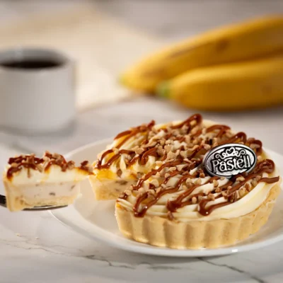 Deliciosa tarta de plátano individual con cremoso relleno, nuez y cajeta sobre masa quebrada. Lo mejor de la repostería artesanal de Pasteli en tamaño personal para disfrutar en Chihuahua.