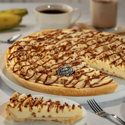 Deliciosa tarta de plátano con cremoso relleno, nuez y cajeta sobre masa quebrada. Lo mejor de la repostería artesanal de Pasteli para disfrutar en Chihuahua.