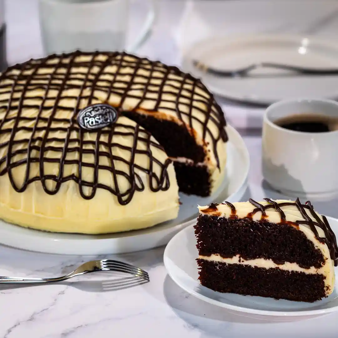 Esponjoso bizcocho de chocolate relleno de queso crema, cubierto con irresistible crema Pasteli y líneas de ganach de chocolate semiamargo. Un deleite tentador para los amantes del chocolate. Pide este indulgente pastel para tus celebraciones a domicilio en Chihuahua.